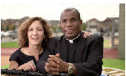 A photo still from the College's 'Acting on our Ethics: Caring for Haiti' video. The still is of a priest and a teacher in Haiti.