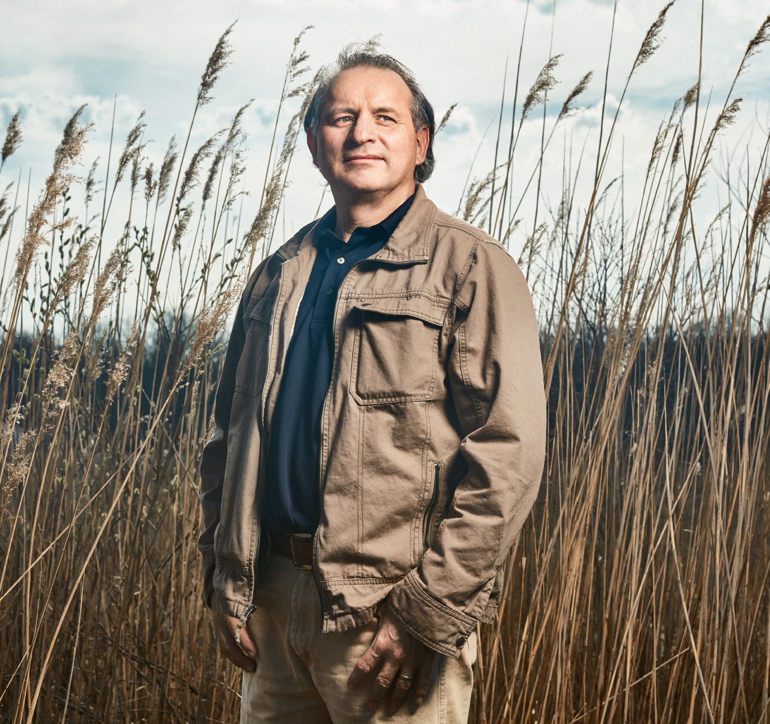 Photo of Tom Deer, Ontario Certified Teacher, standing in a field of tall grass.