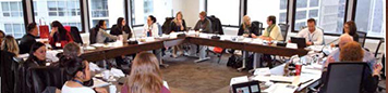 Photo of a group of provincial AQ writers seated at a table during an AQ development consultation.
