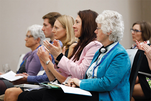 Photo of a group of people applauding.