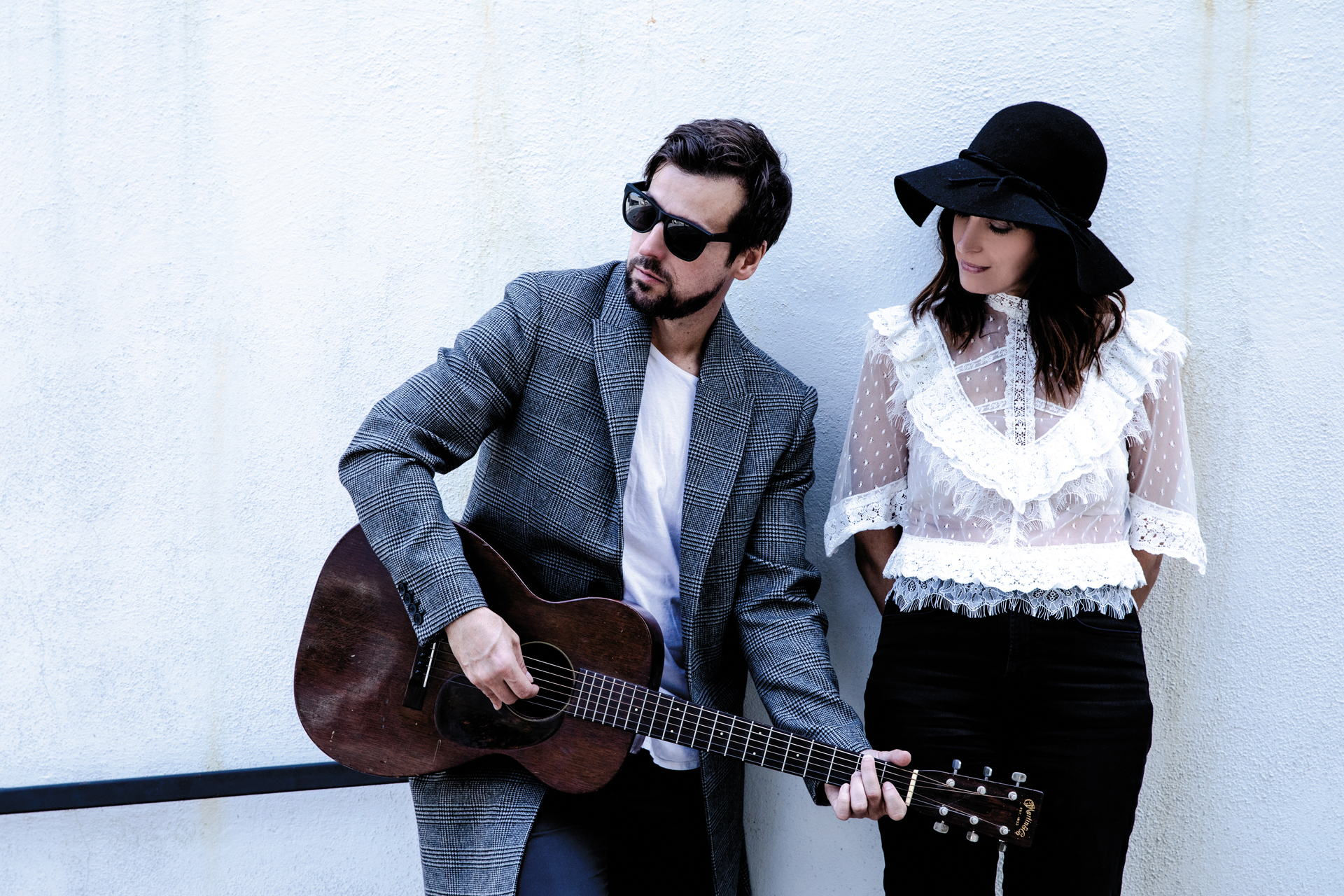 Photo of Chantal Kreviazuk, a celebrated musician and singer, with Raine Maida, the lead vocalist of Our Lady Peace. Chantal Kreviaszuk looks at the acoustic guitar that Raine Maida is playing.