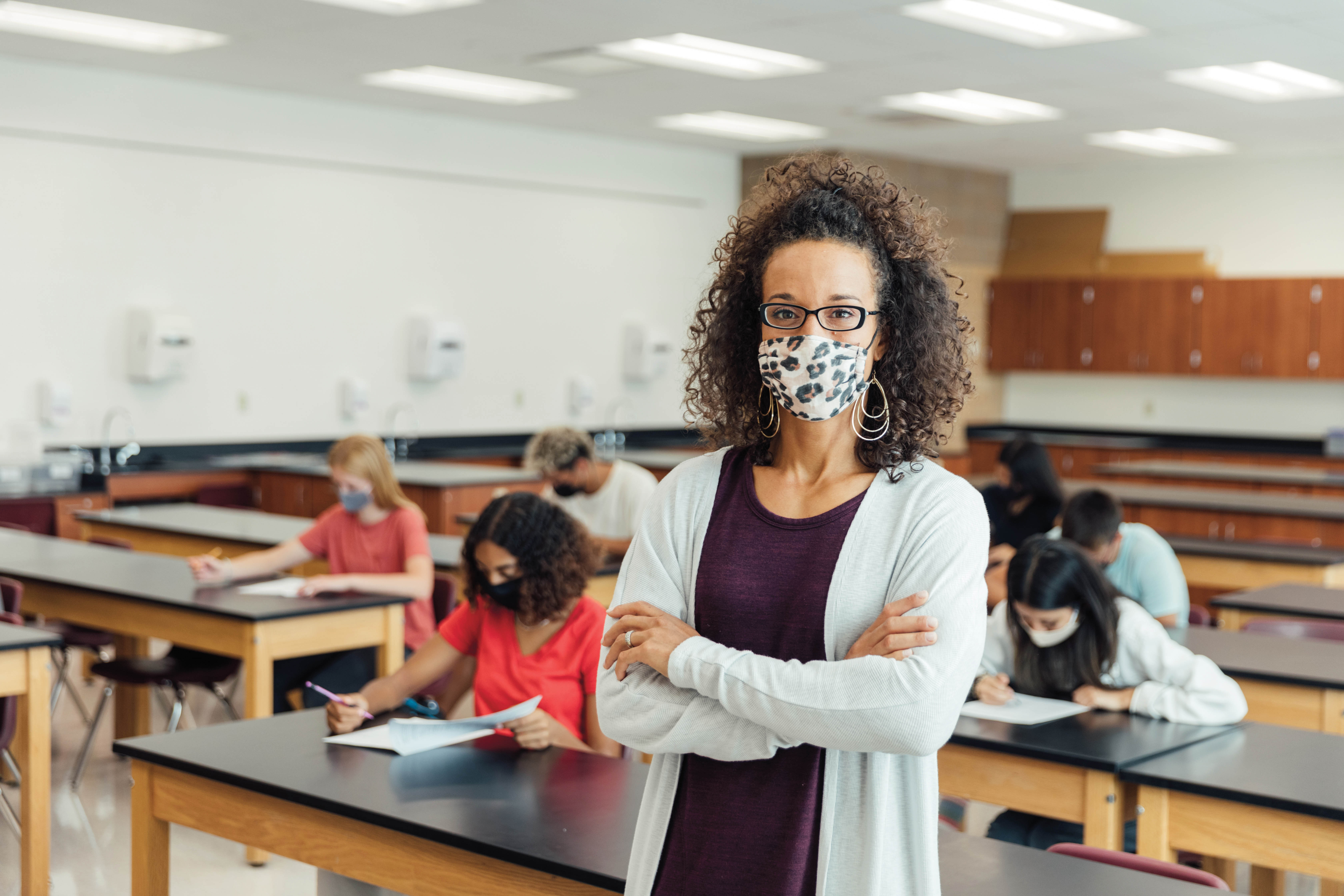 Teacher in classroom wearing a mask.