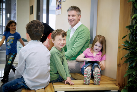 A photo of College Registrar Michael Salvatori seated with young students.