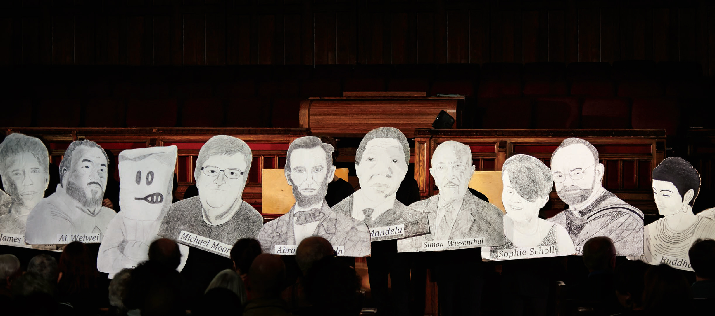 A photo of students holding up pencil illustrations of the following people: Ai Weiwei, Michael Moore, Abraham Lincoln, Nelson Mandela, Simon Wiesenthal and Sophie Scholl.