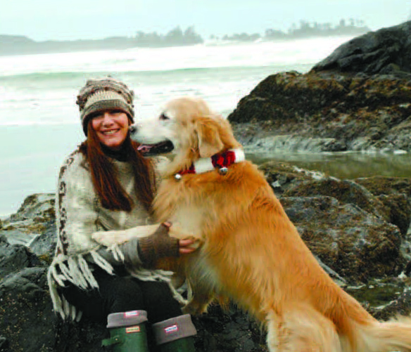 A photo of Kirstine Stewart’s former Acton High School teacher Suzi Beber with a golden retriever dog. They are sitting on the coast of Tofino, B.C.