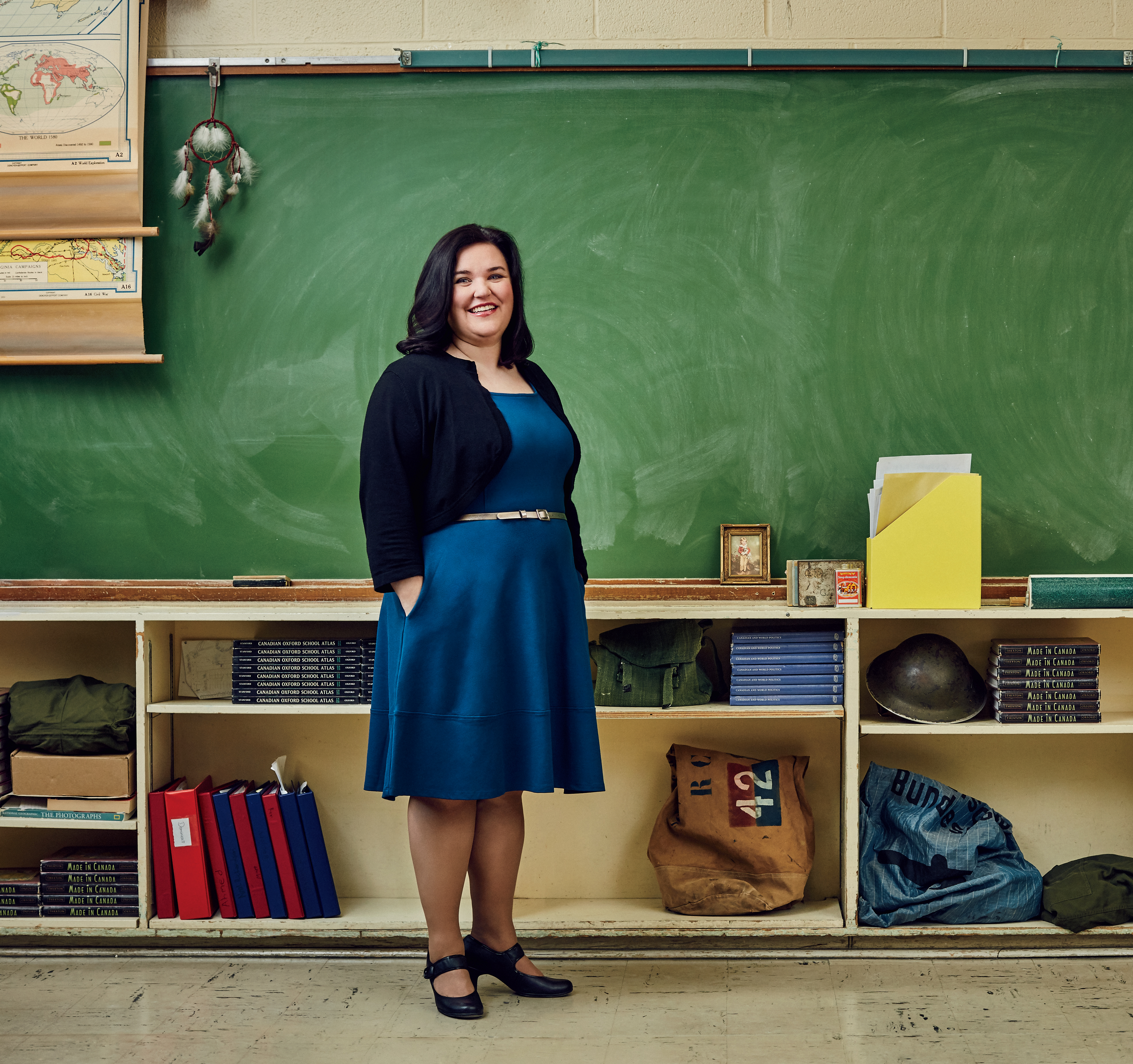 A photo of Kathryn Whitfield, Ontario Certified Teacher, standing in front of a classroom chalkboard.