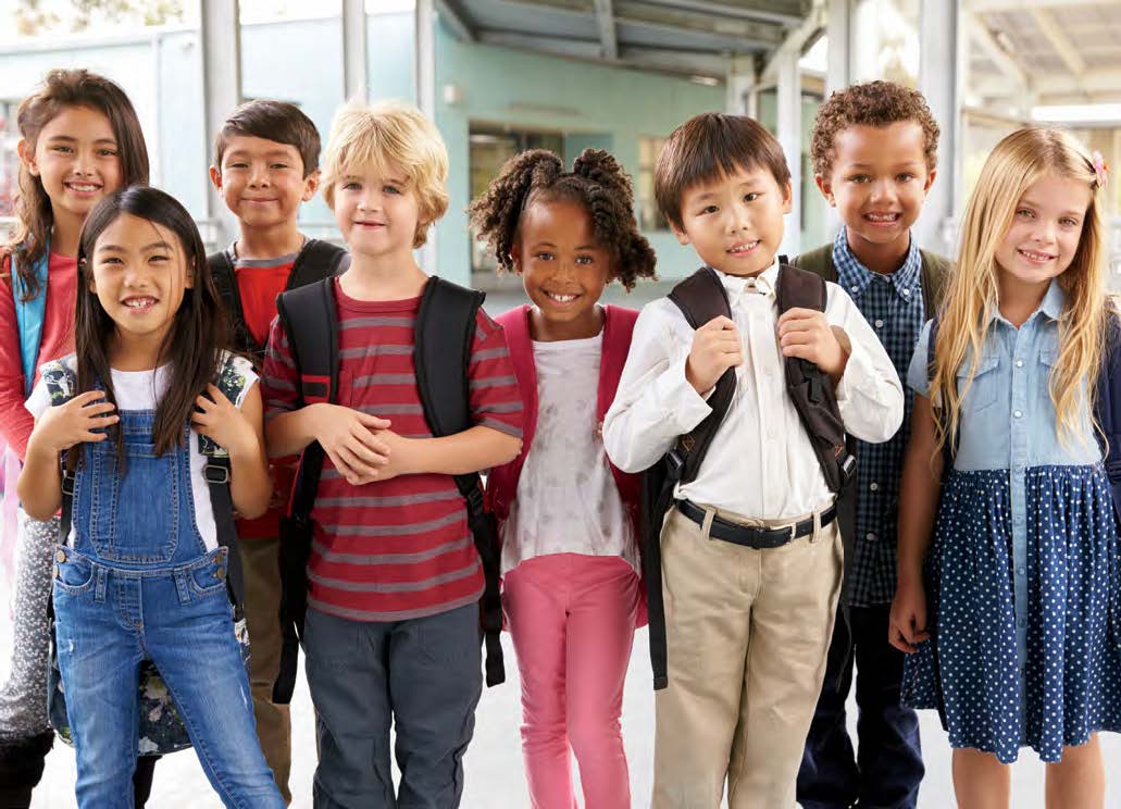 Photo of a group of young students standing together. They are all smiling.