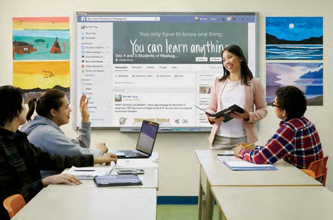 Photo of Min Min Tong standing at the front of a classroom and delivering a presentation to teenaged students.