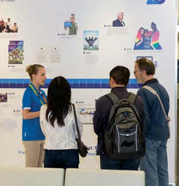 Photo of a College staff person speaking with visitors.