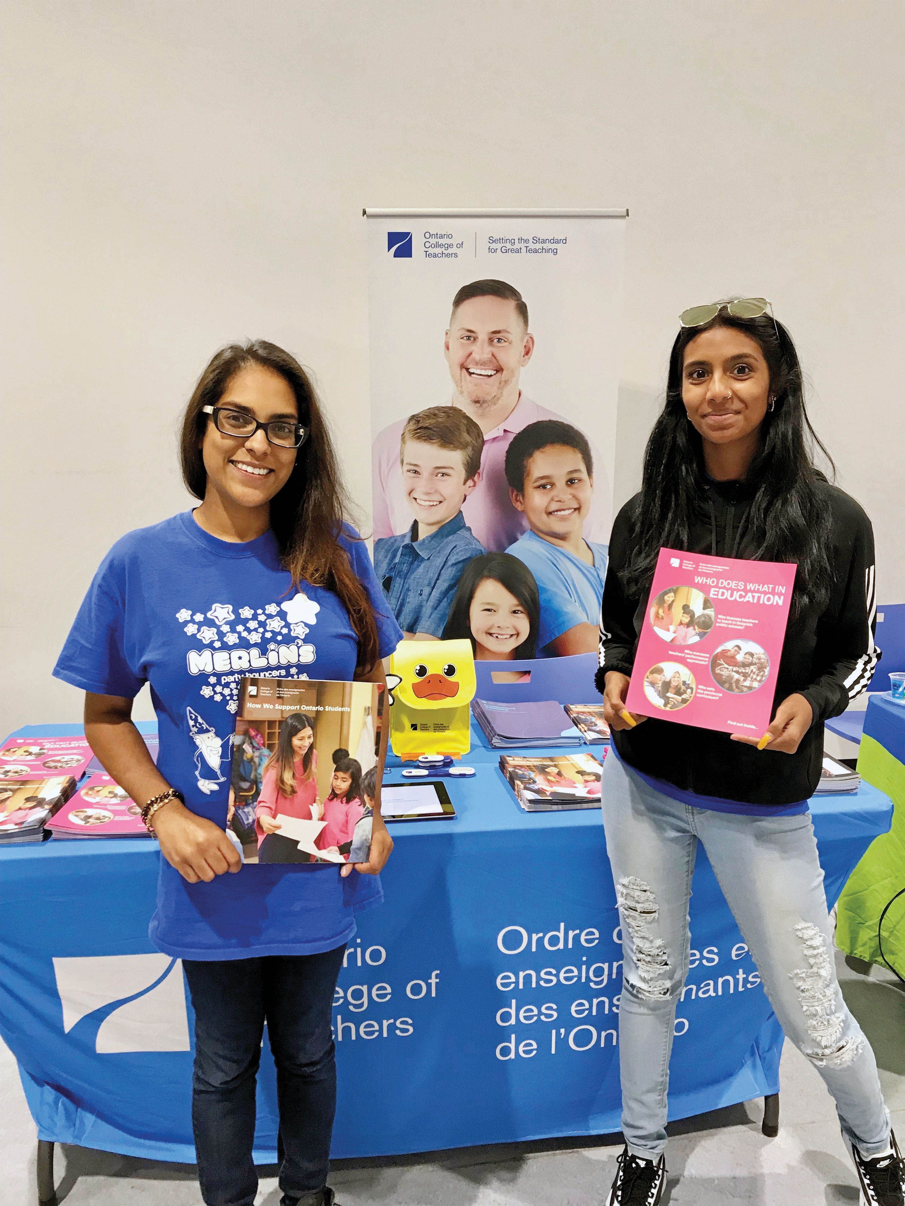 Photo of two parents at a College booth during a community event in Scarborough.