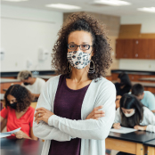 Teacher in classroom wearing mask.